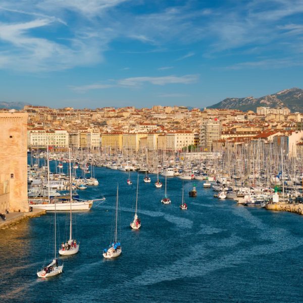 Yachts coming from boat regatta to Marseille Old Port (Vieux-Port de Marseille) on sunset and Fort Saint-Jean. Marseille, France